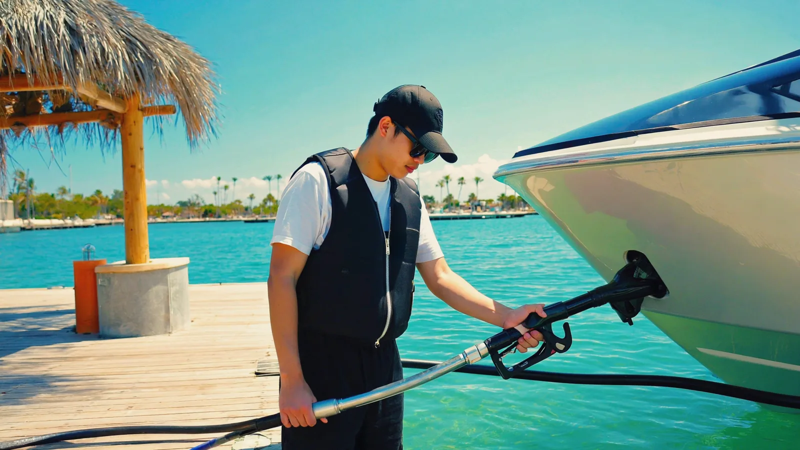 A young man fueling a wake boat at a Florida marina fuel dock